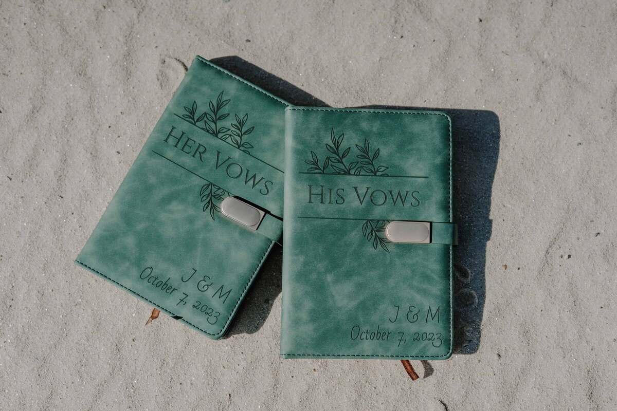 his and her vow books on the sandy beach of rumbling bald at lake lure