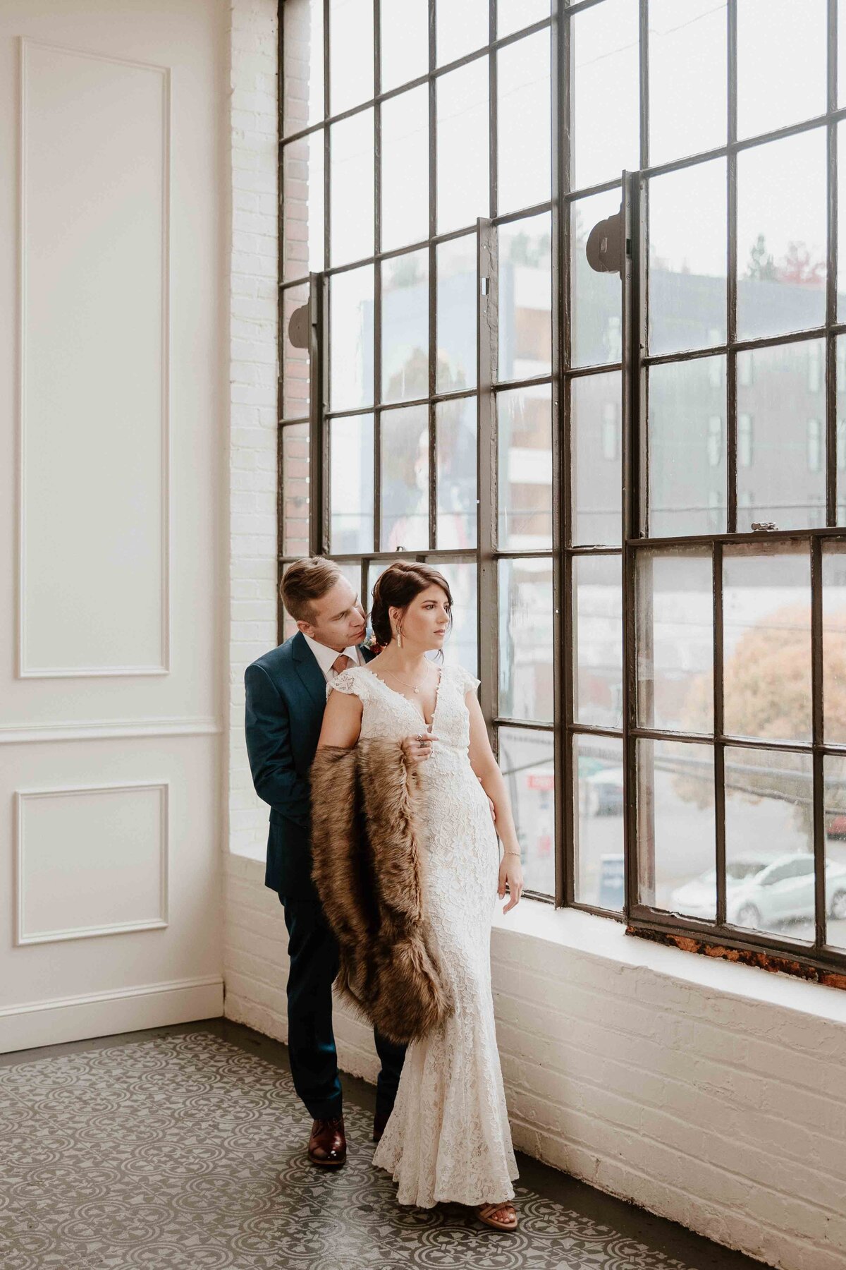 bride and groom in front of the huge window at Tendue in Portland Oregon