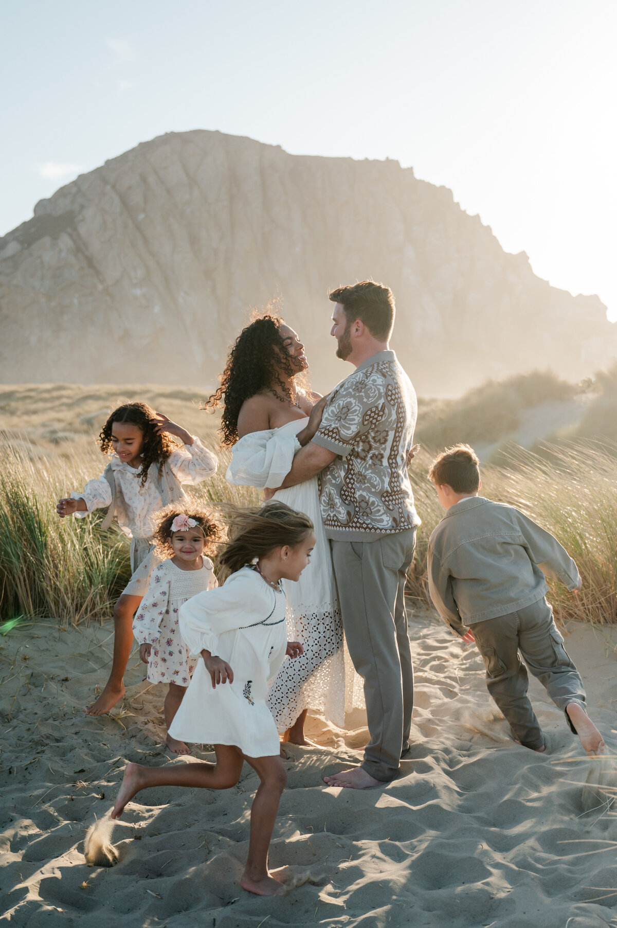 Candid family photo with Morro Rock in the background, capturing love and connection by the coast.