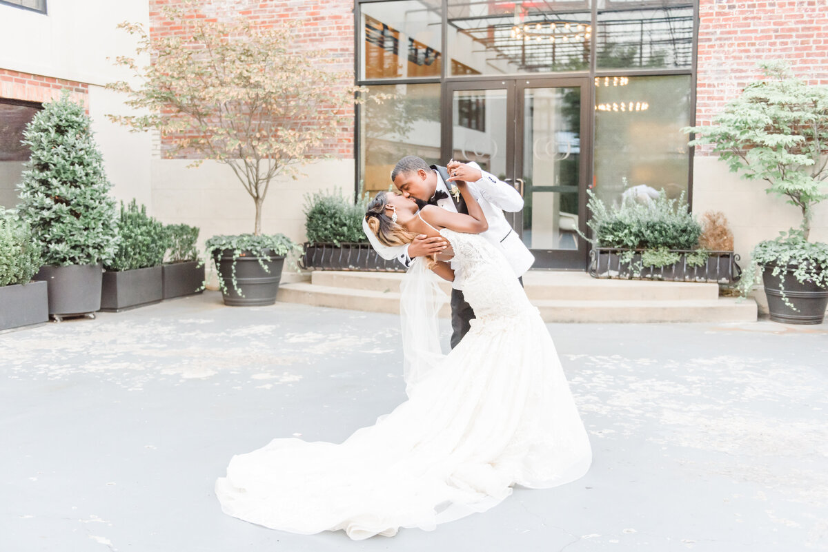 groom dipping bride for a kiss while dancing in the courtyard at Vie