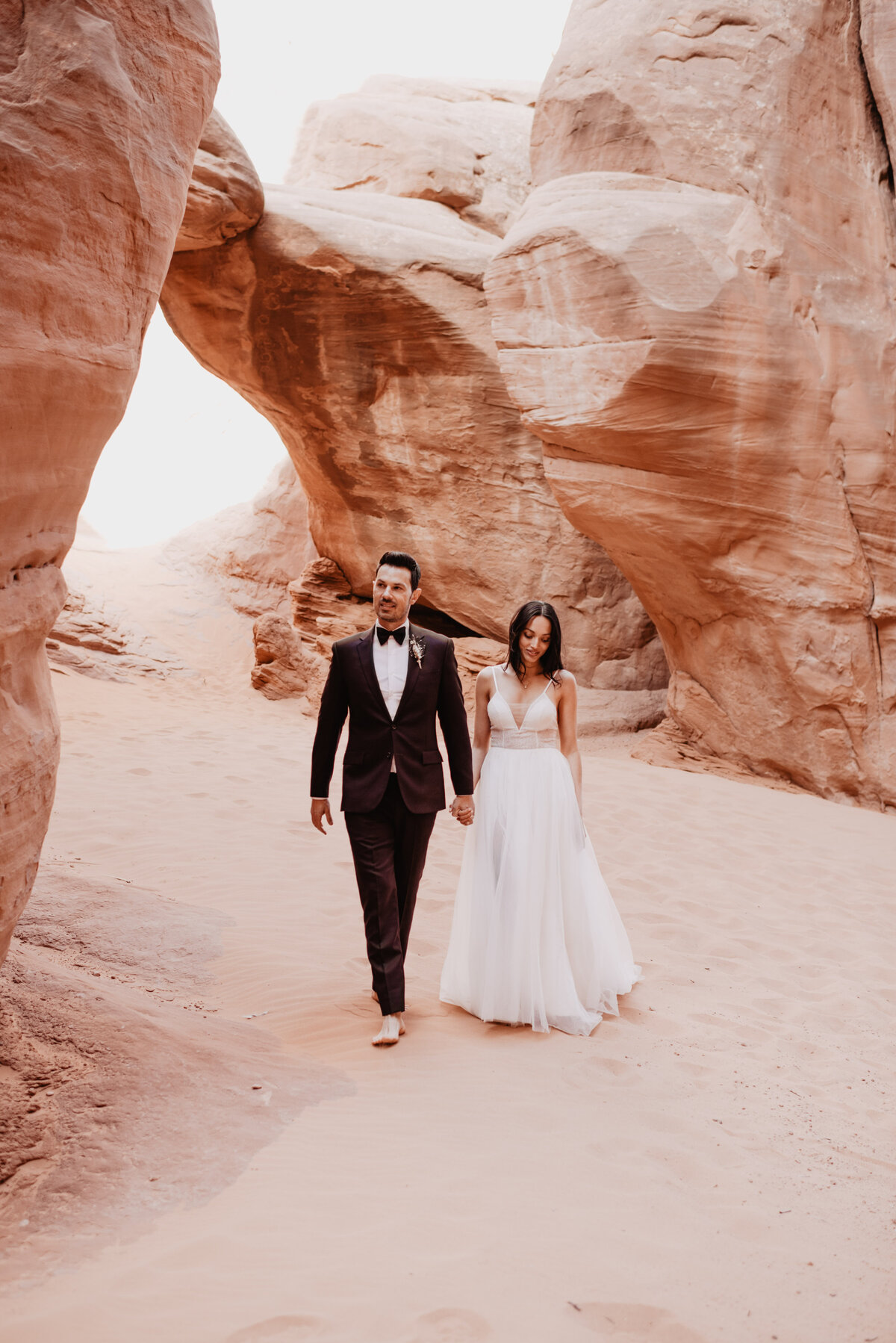 Utah elopement photographer captures husband and wife holding hands and walking together