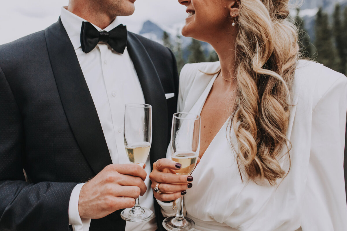 Bride and groom champagne toast their wedding at The Malcolm Hotel, a modern romantic wedding venue in Canmore, featured on the Brontë Bride Vendor Guide.