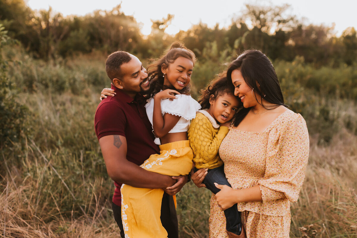 gorgeous black family of four smiling and holding each other