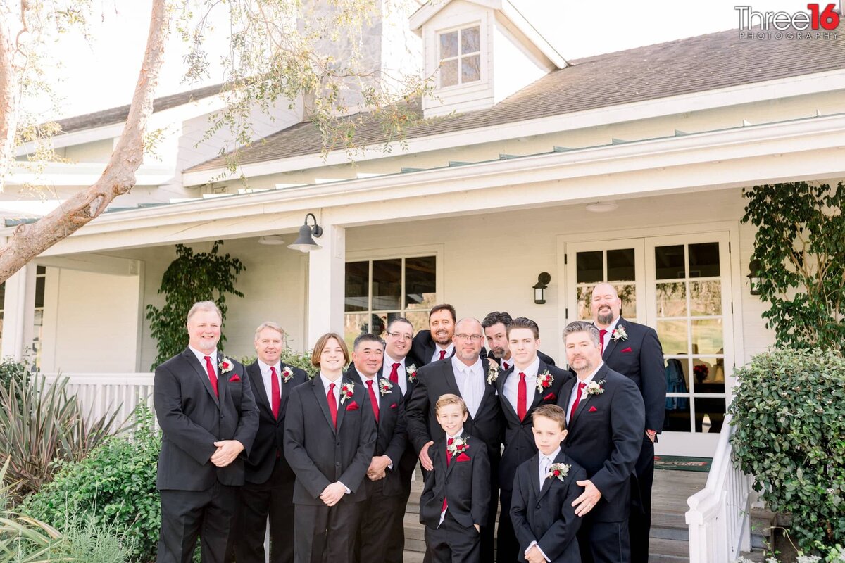 Groom poses with his Groomsmen in front of the clubhouse