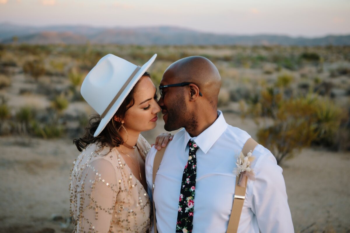 A bride and groom kiss in Joshua Tree national park on their adventure elopement day