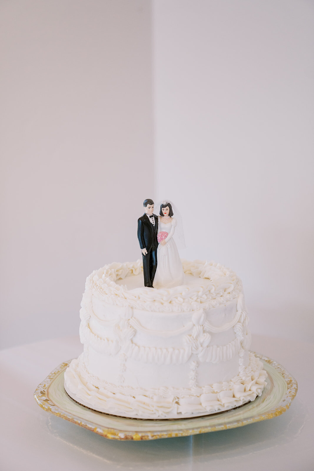 Classic white wedding cake with a vintage bride and groom cake topper.