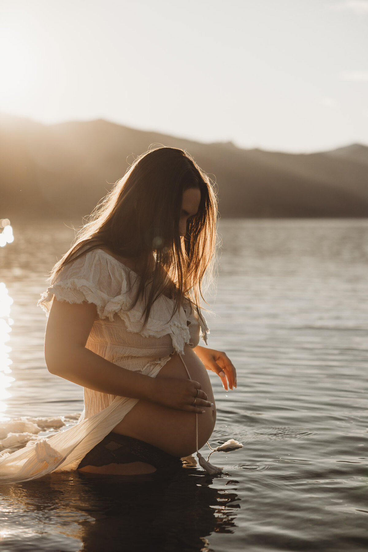 pregnant woman standing in the lake during her maternity session