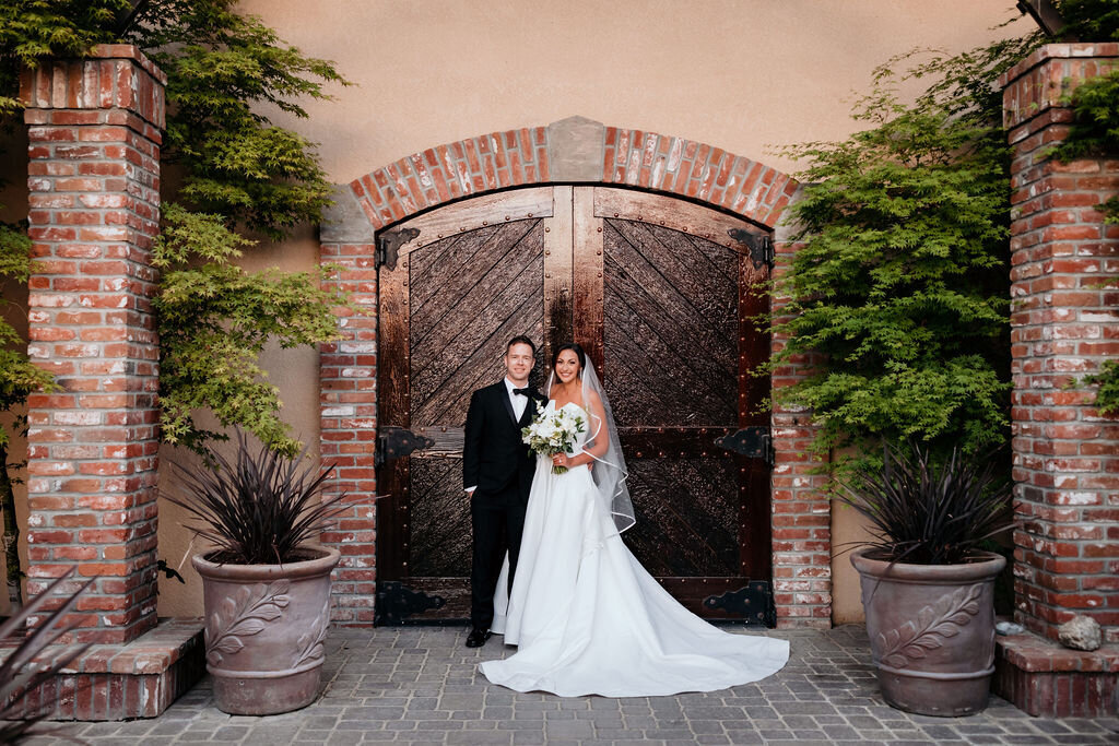 Bride and groom standing in front of the Palm Event Center in Pleasanton, CA, during their spring wedding.