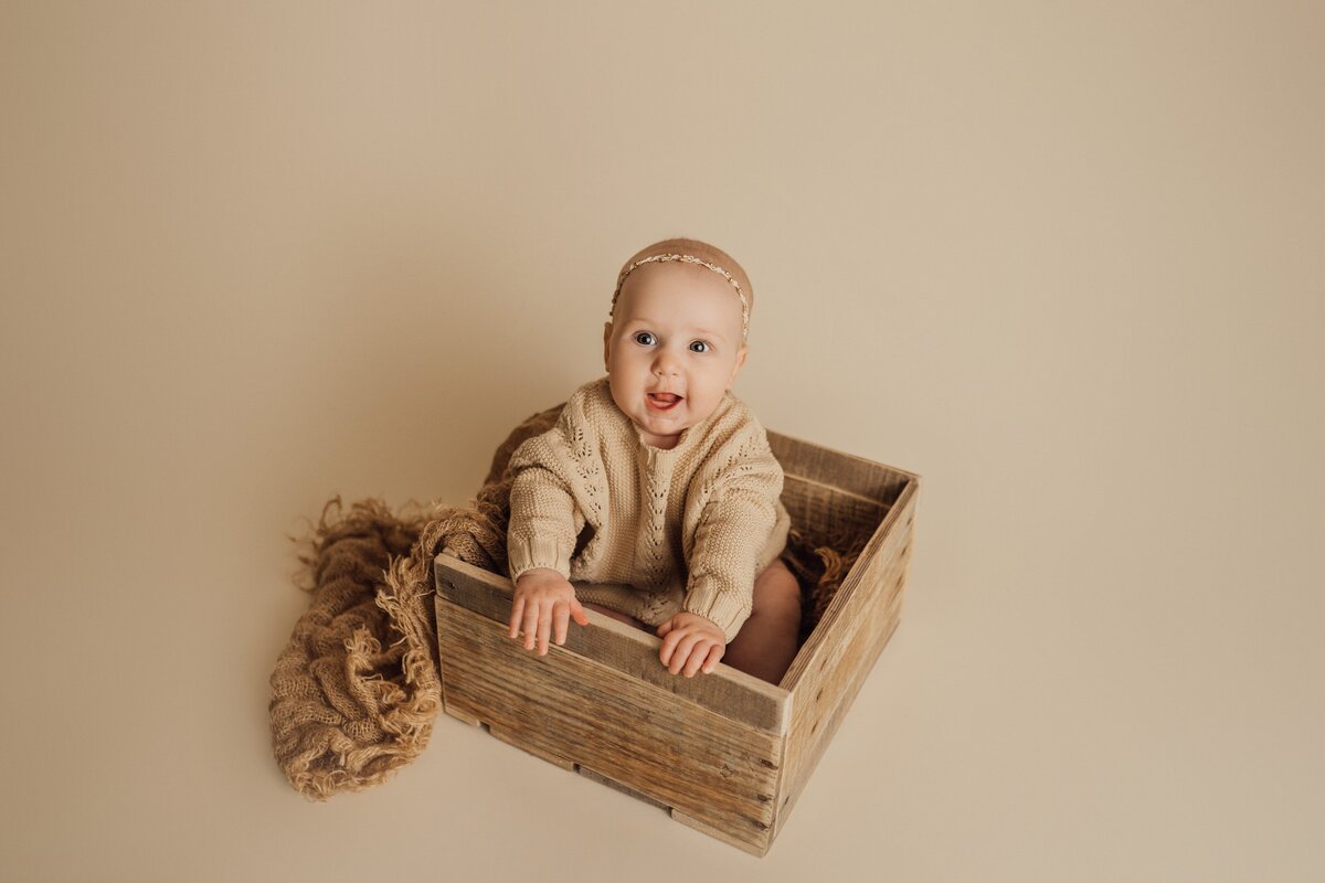 baby girl in crate poses during 6 month session in st. pete