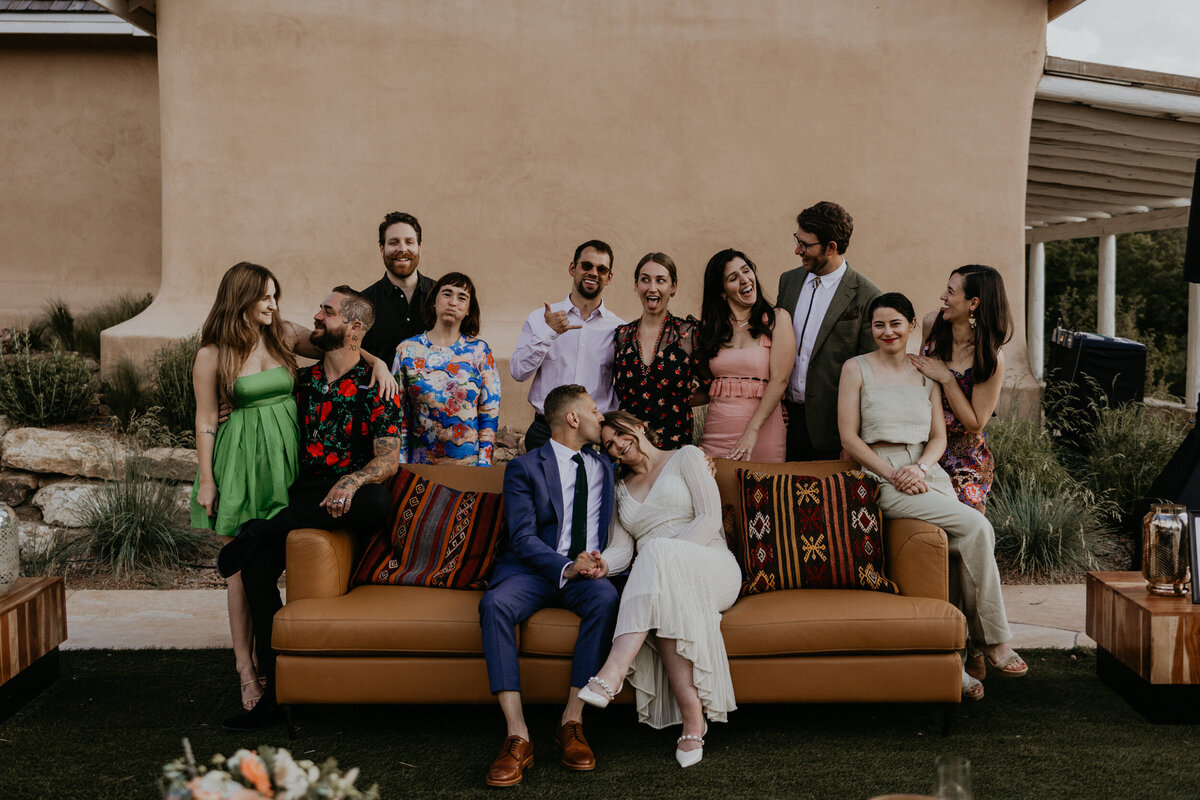 newlyweds posing with their friends on a couch
