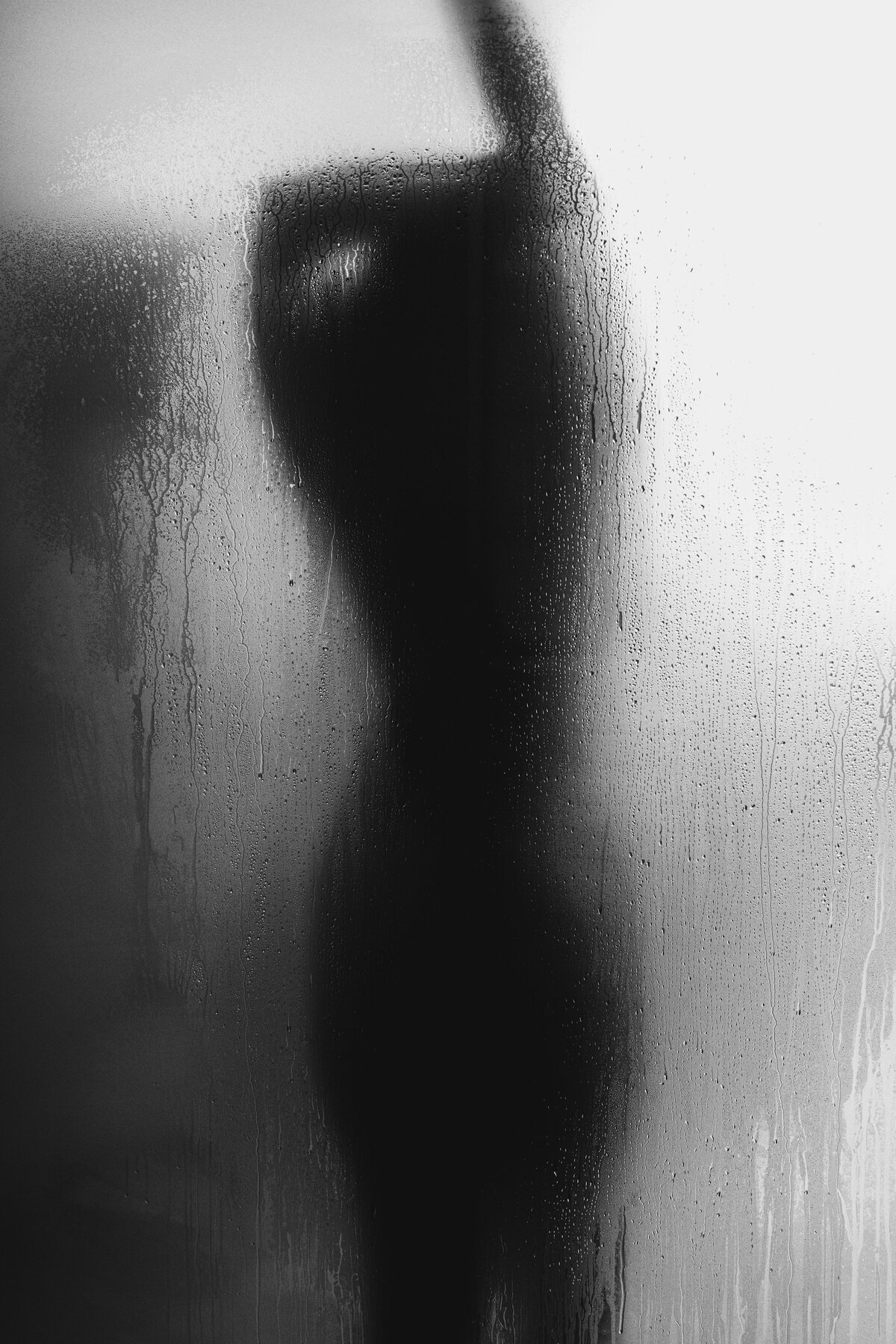 Plus sized female silhouette behind a shower door