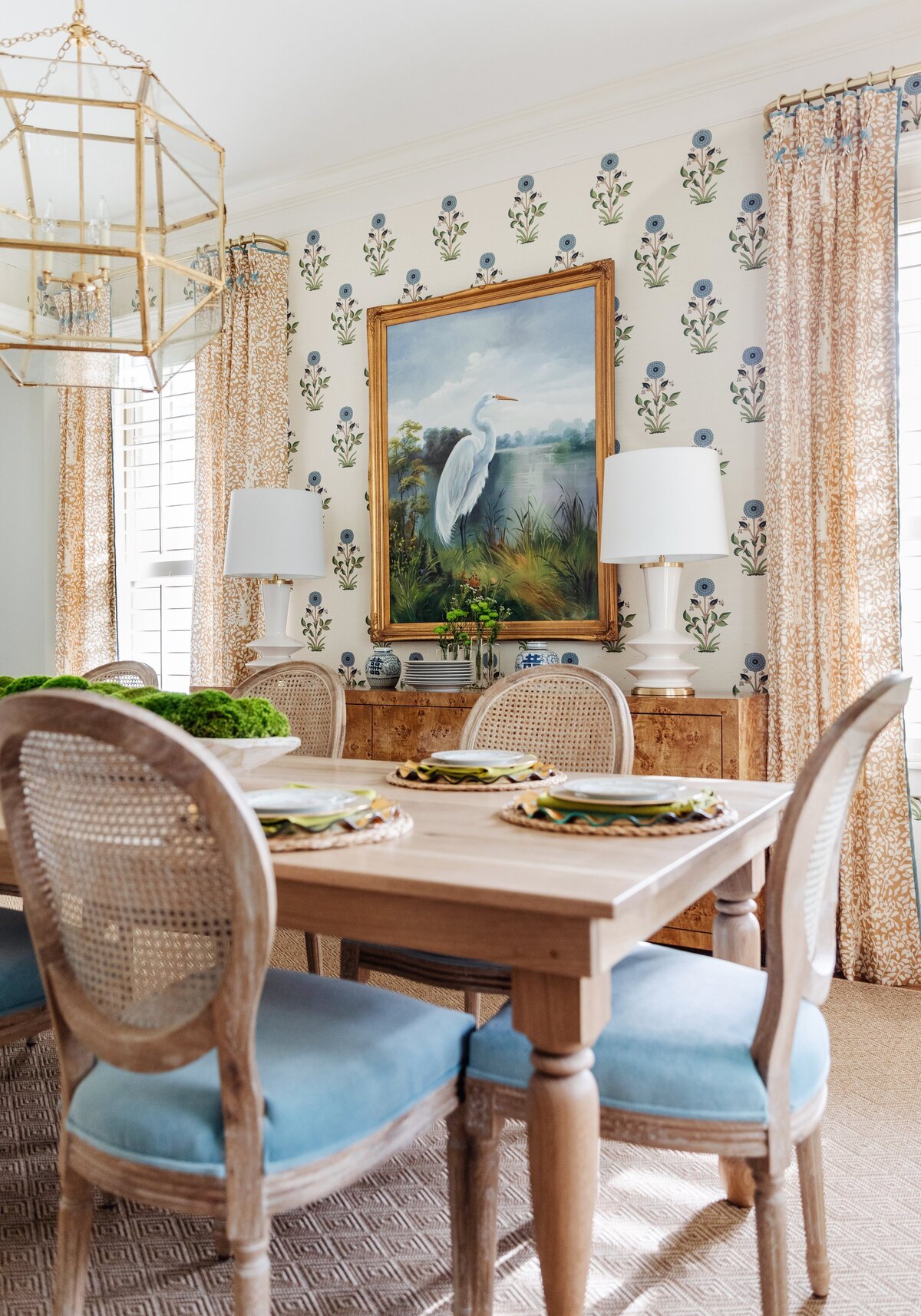 oyster creek studios oak forest remodel wooden dining room table with wooden chairs with blue cushions and heron painting in dining room