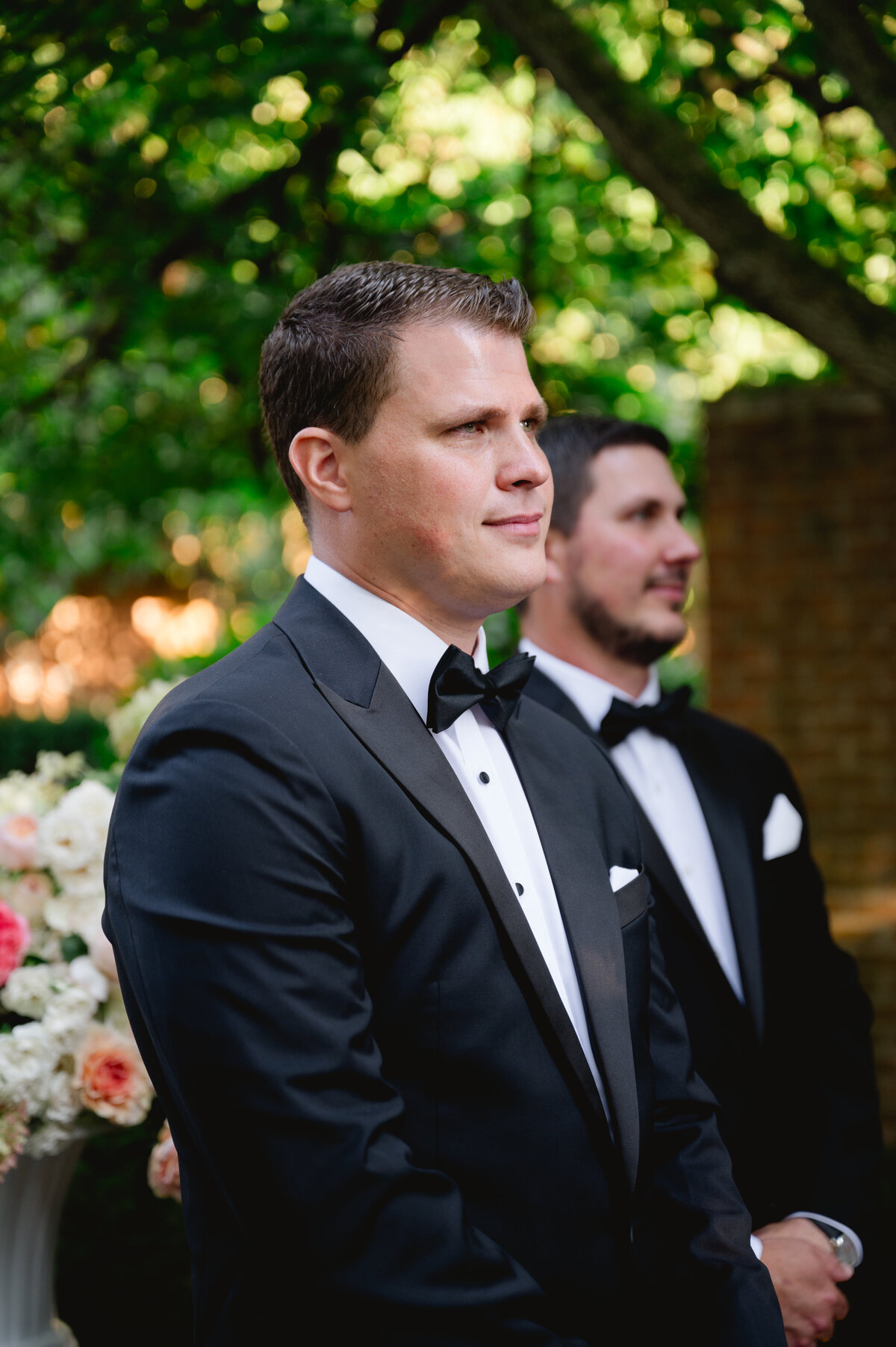 Groom looking on intently during a wedding ceremony at the Chicago Botanic Gardens.
