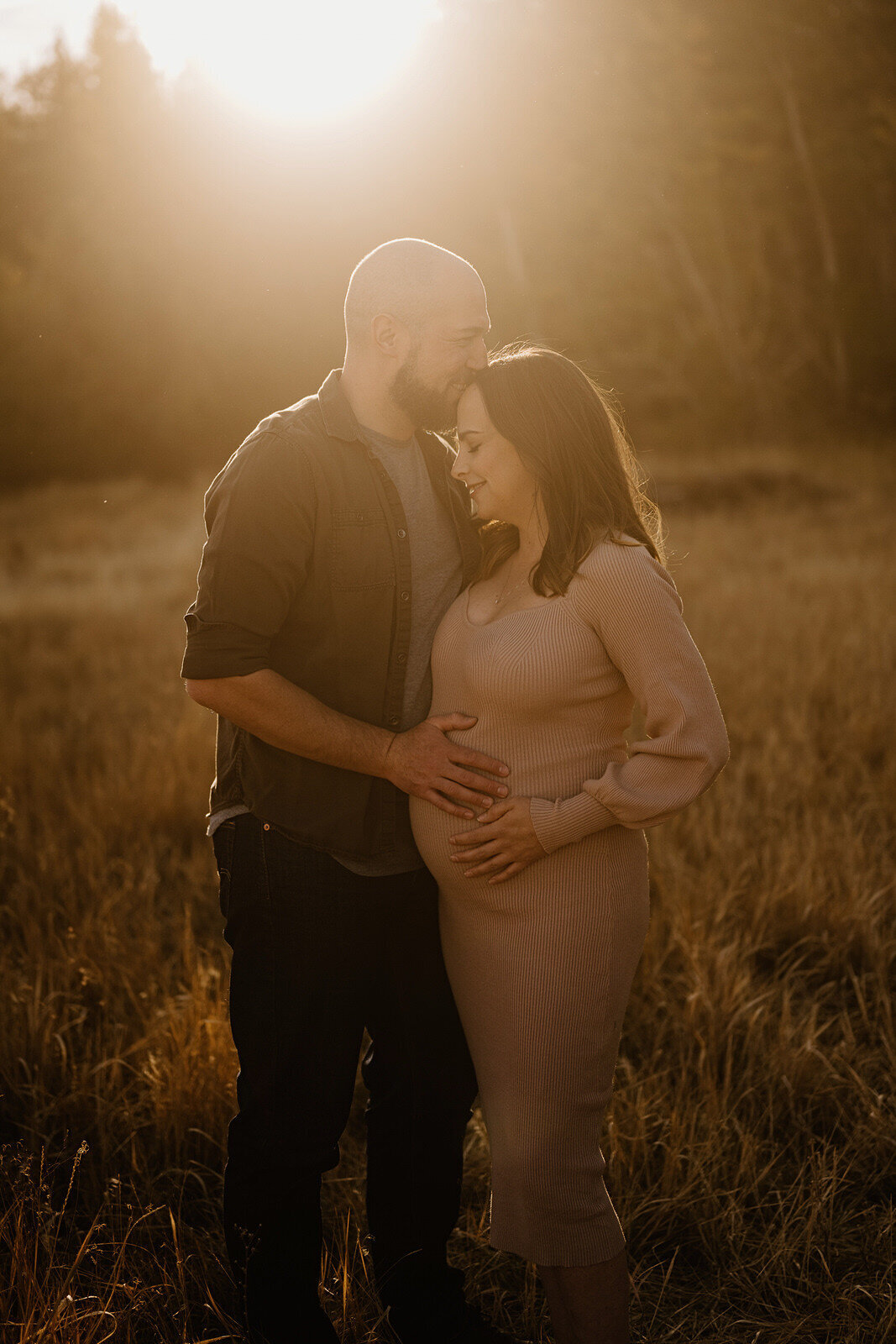 Couple with pregnant belly at sunset