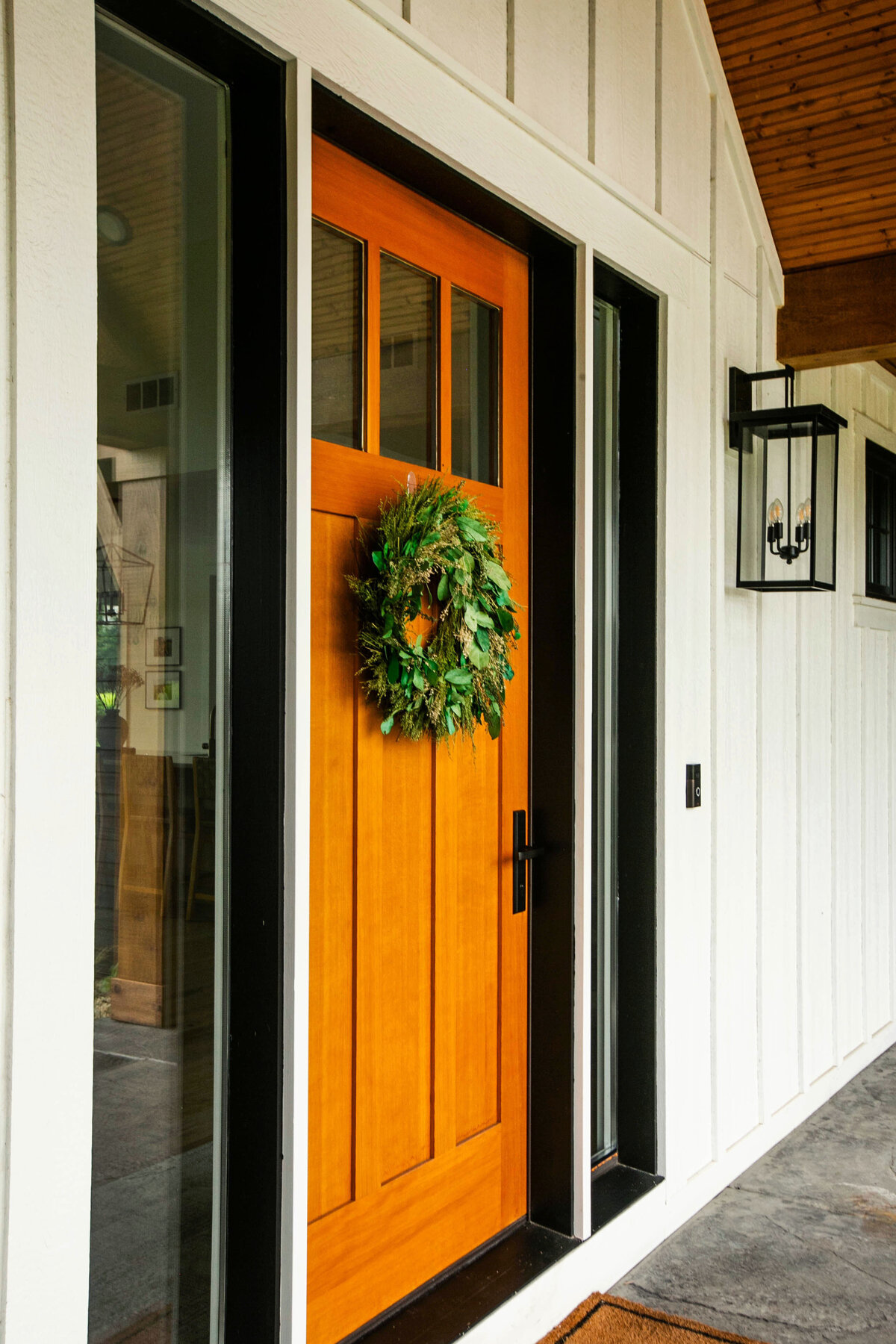 Exterior view of custom home in Otsego, Minnesota with modern wood details and front porch built by Cornerstone Custom Builds