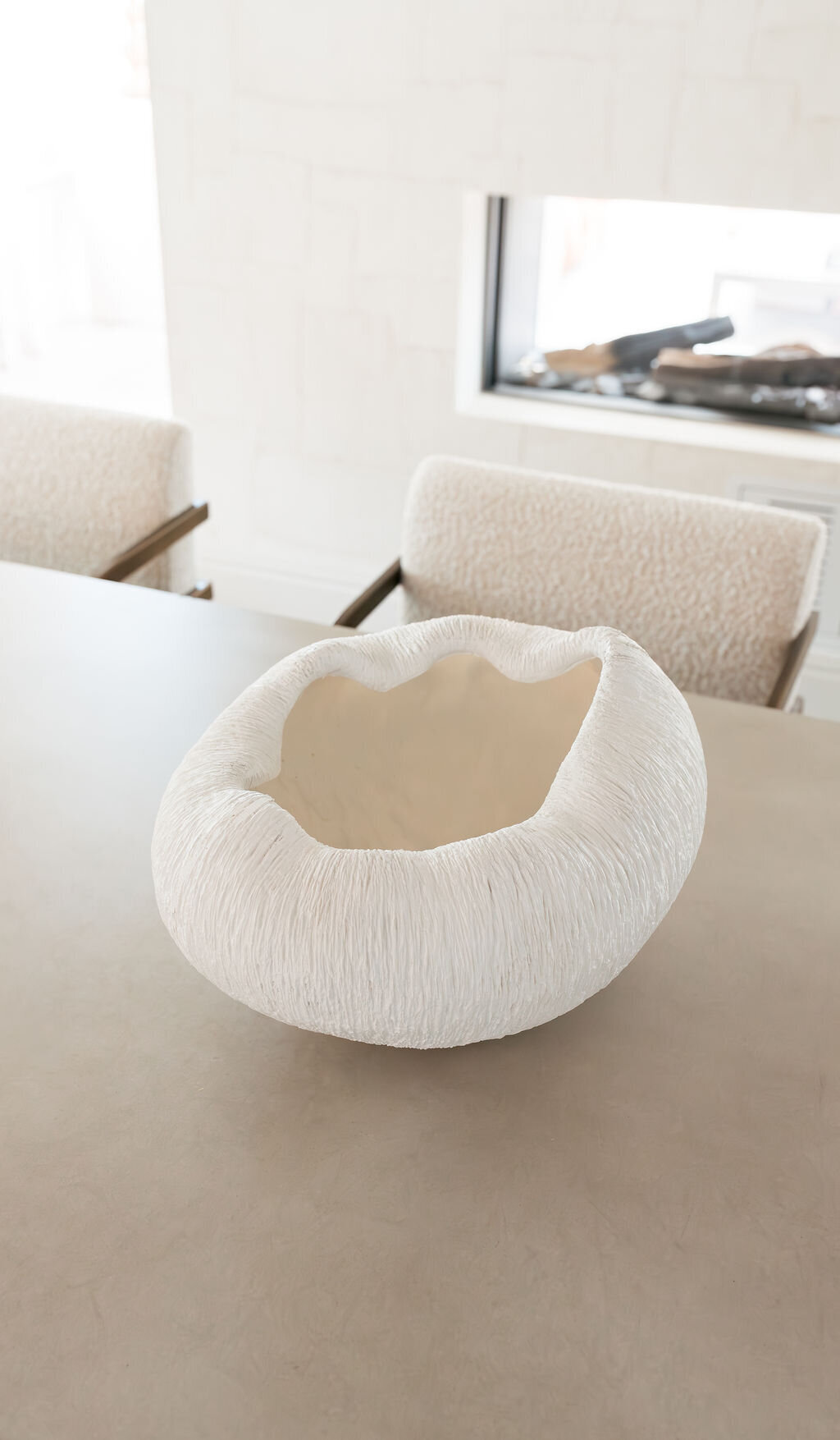 A large contemporary white bowl atop the dining room table.