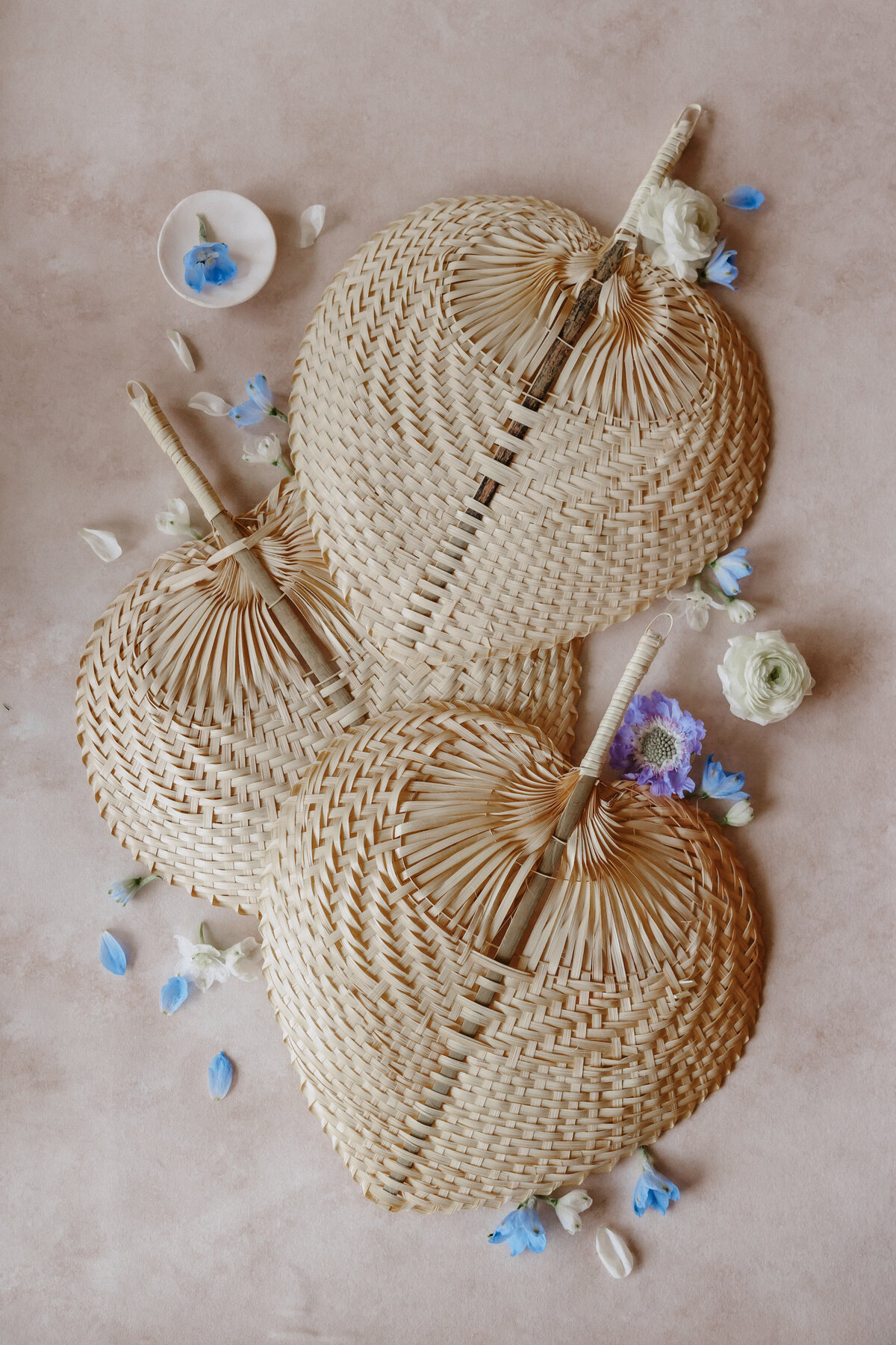 wedding ceremony fan guest favor used for detail flat lay with blue, purple and white florals