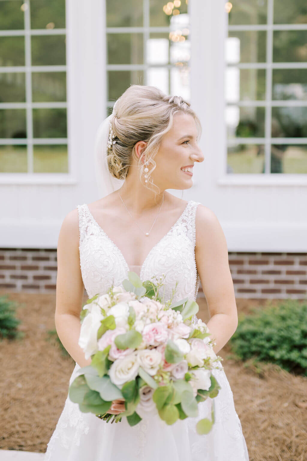 Bridal portrait while bride is looking away and holding bouquet