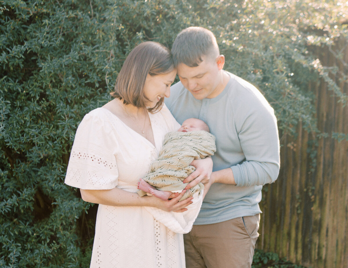 Mother and Father holding newborn baby in gardens by Oklahoma City Photographer Courtney Cronin