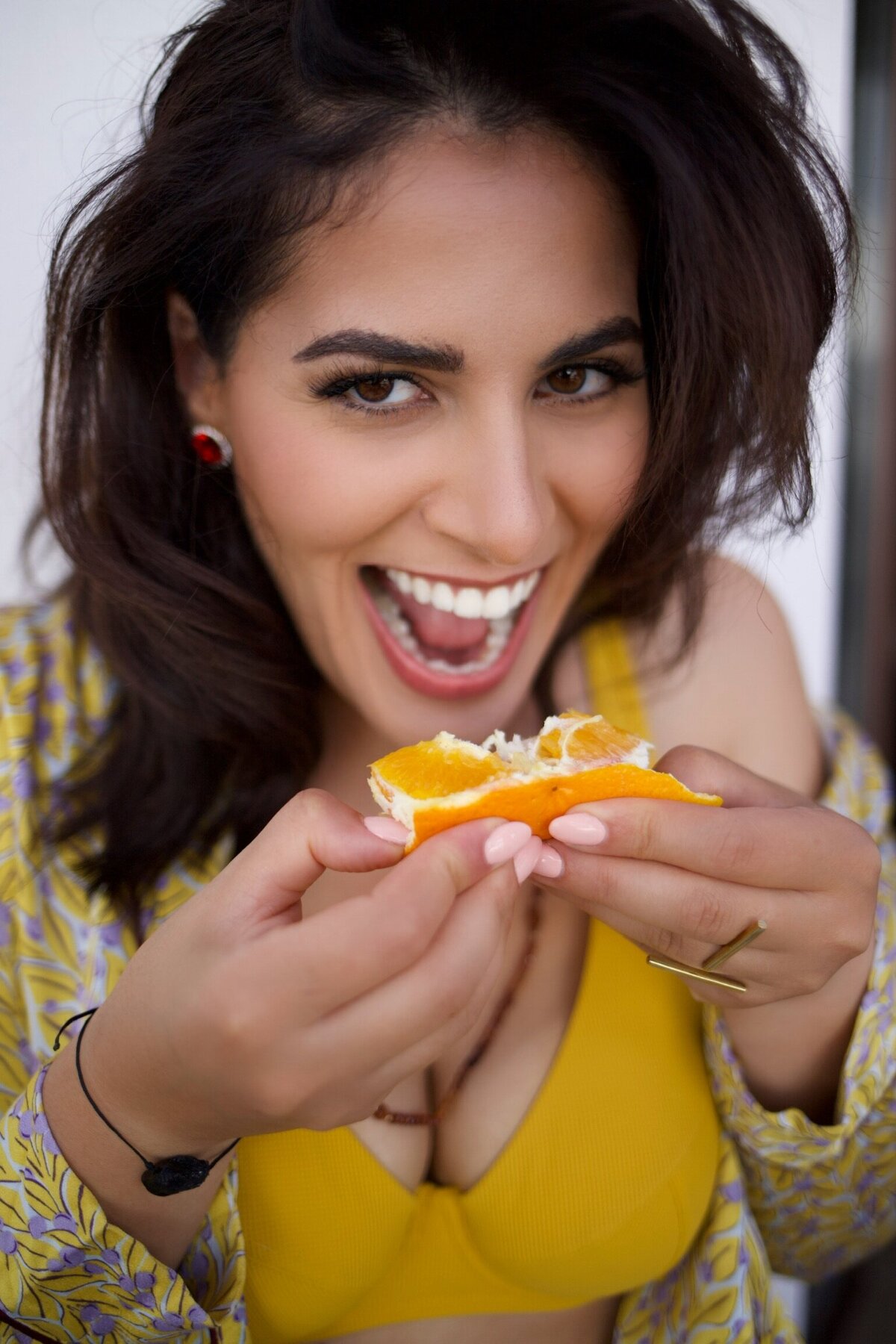 woman holding an orange slice to her mouth