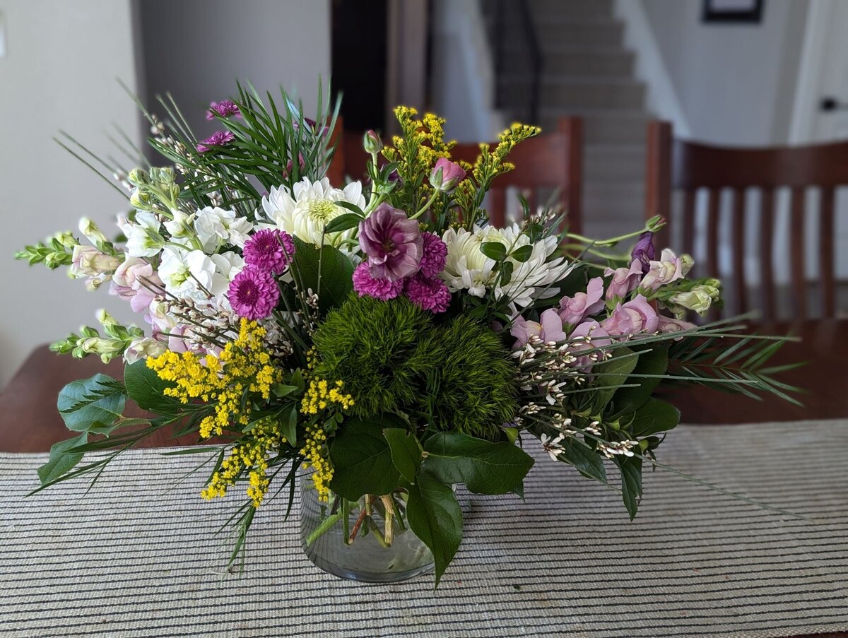 white funeral flowers with purple and yellow