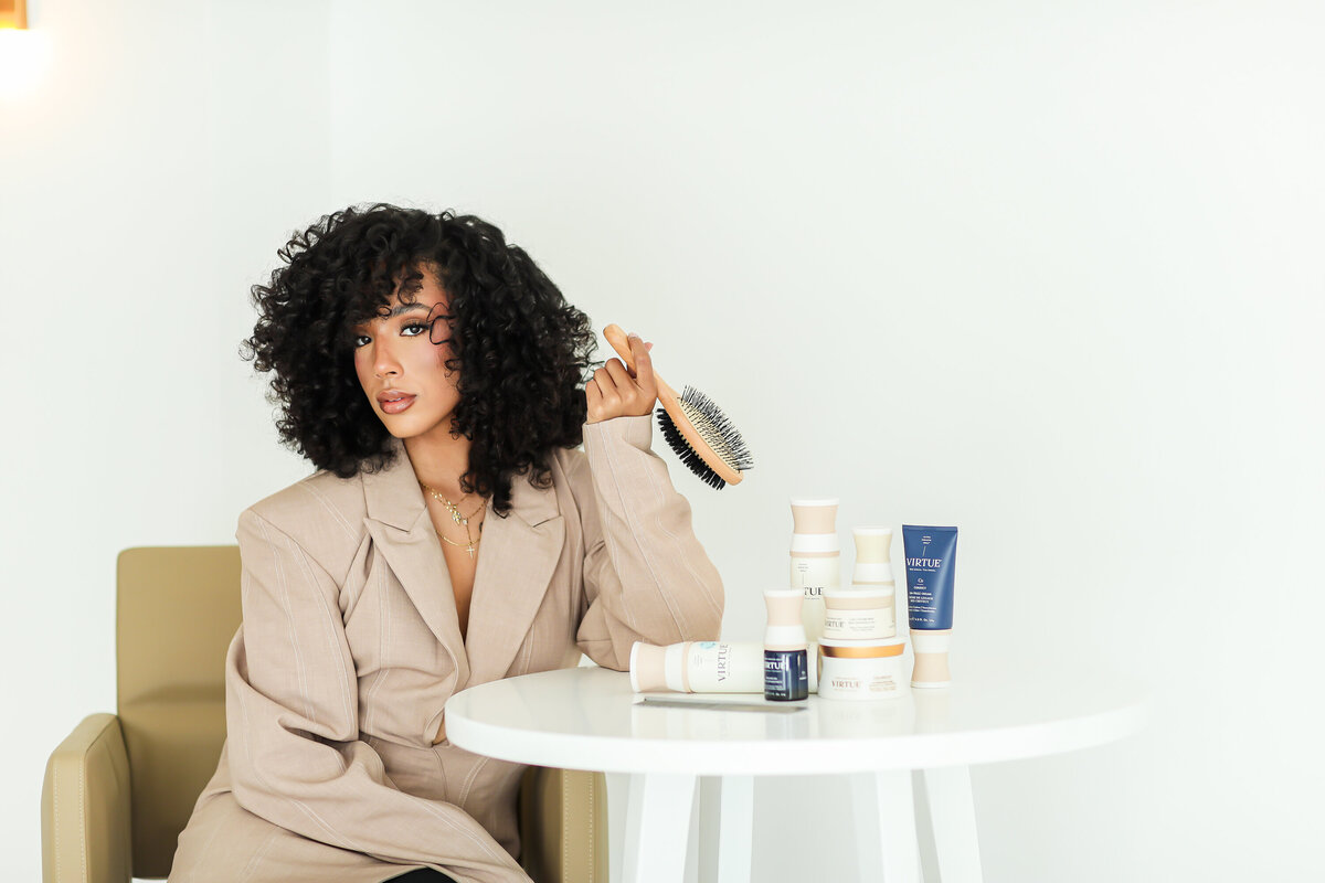 Model sitting in chair with hair products