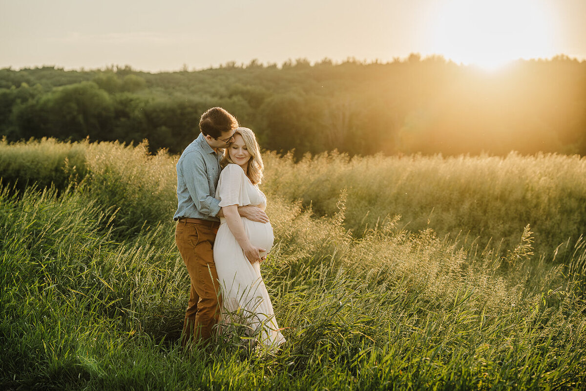 little boy touches moms pregnant belly during boston maternity photo session