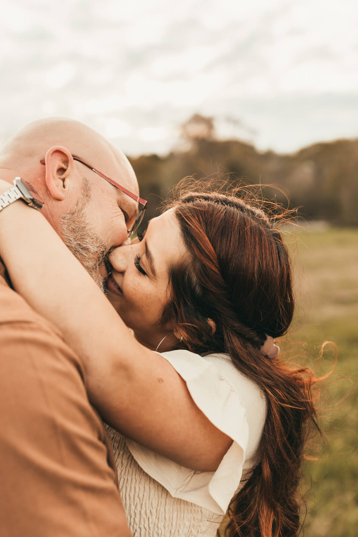 husband and wife kiss for a sweet moment during family session.