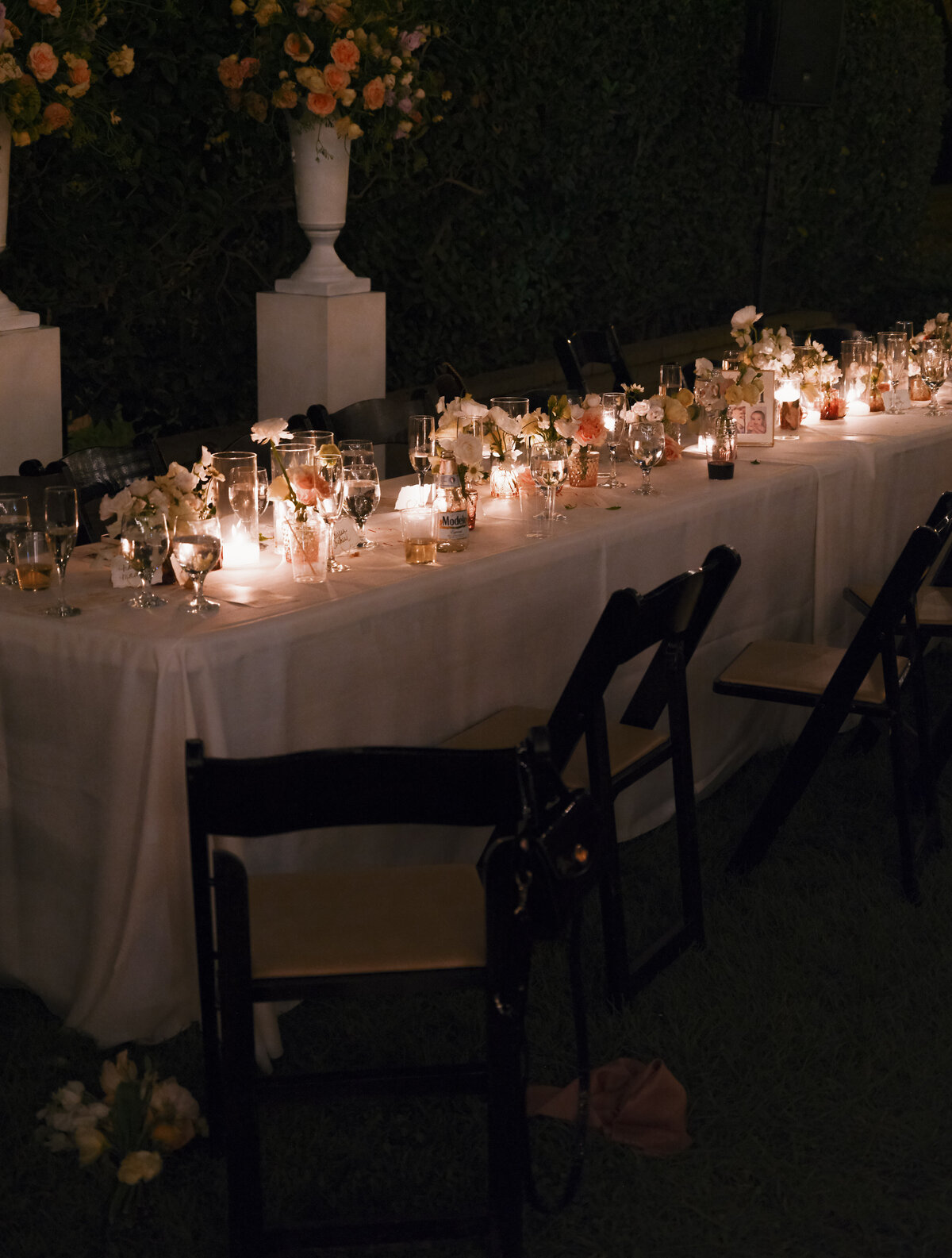 wedding reception table with glowing candles and florals