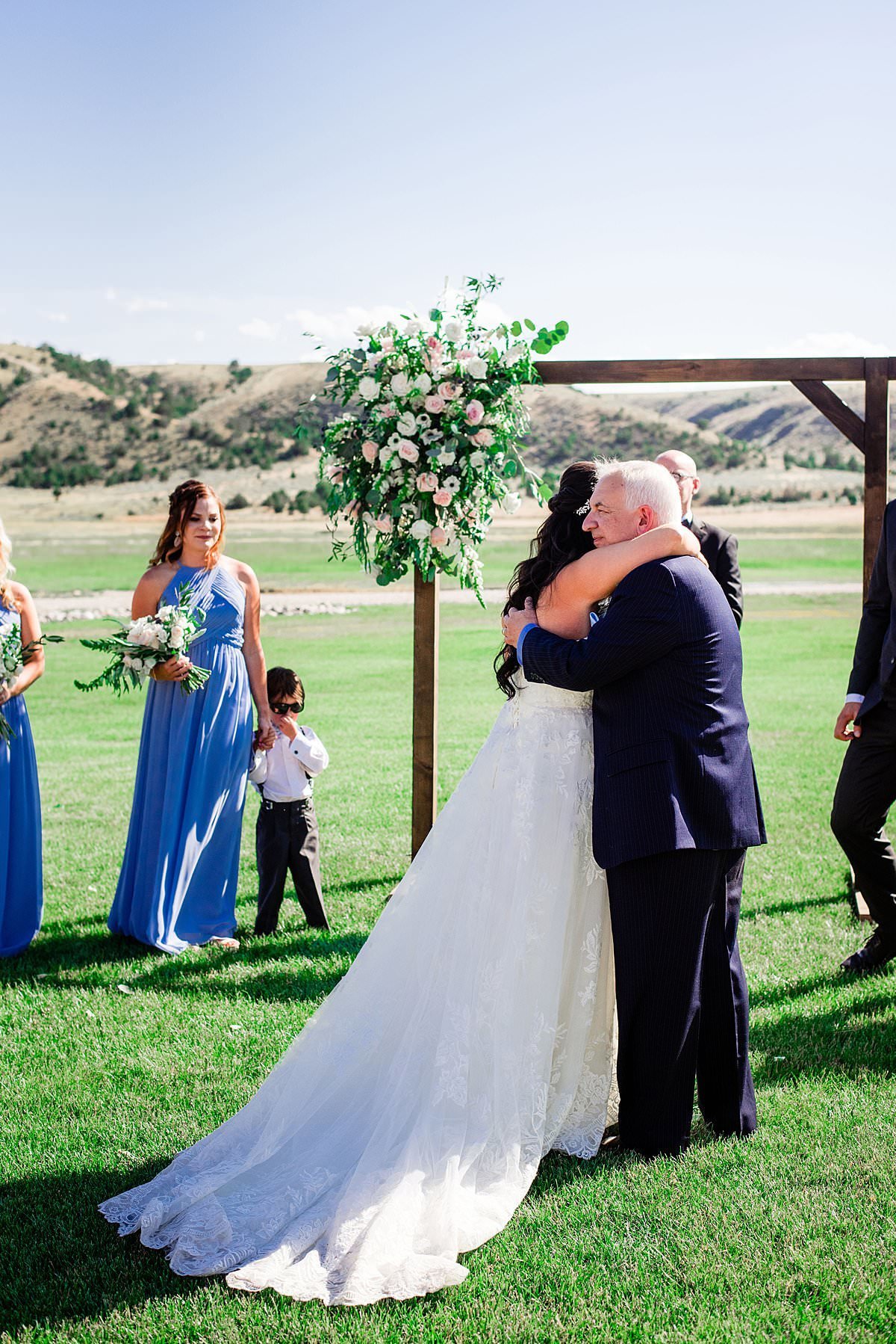 Father of the bride hugging her dad as he gives her away on her wedding day