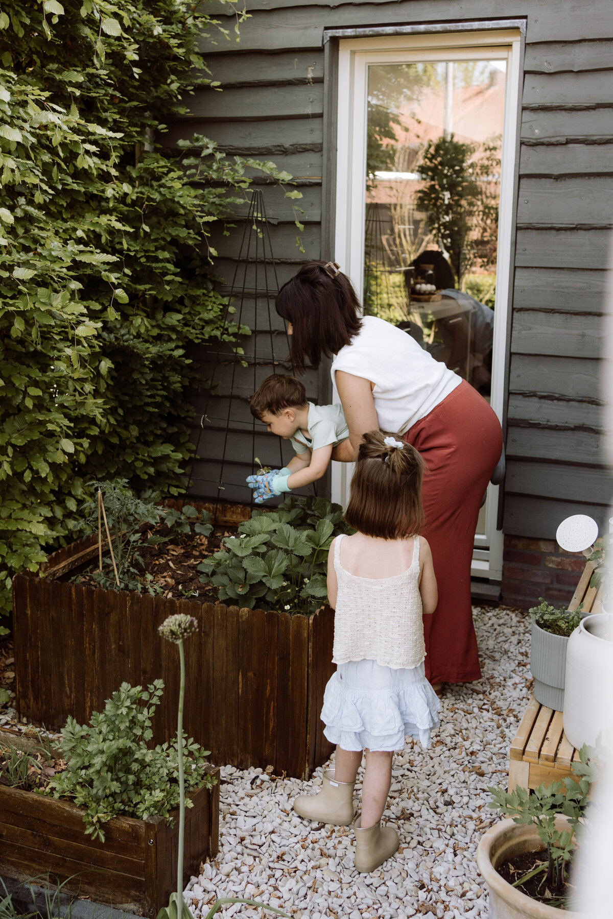 Lifestyle gezinsfotografie tijdens een Homes to Remember-shoot - plantjes poten in de moestuin 
