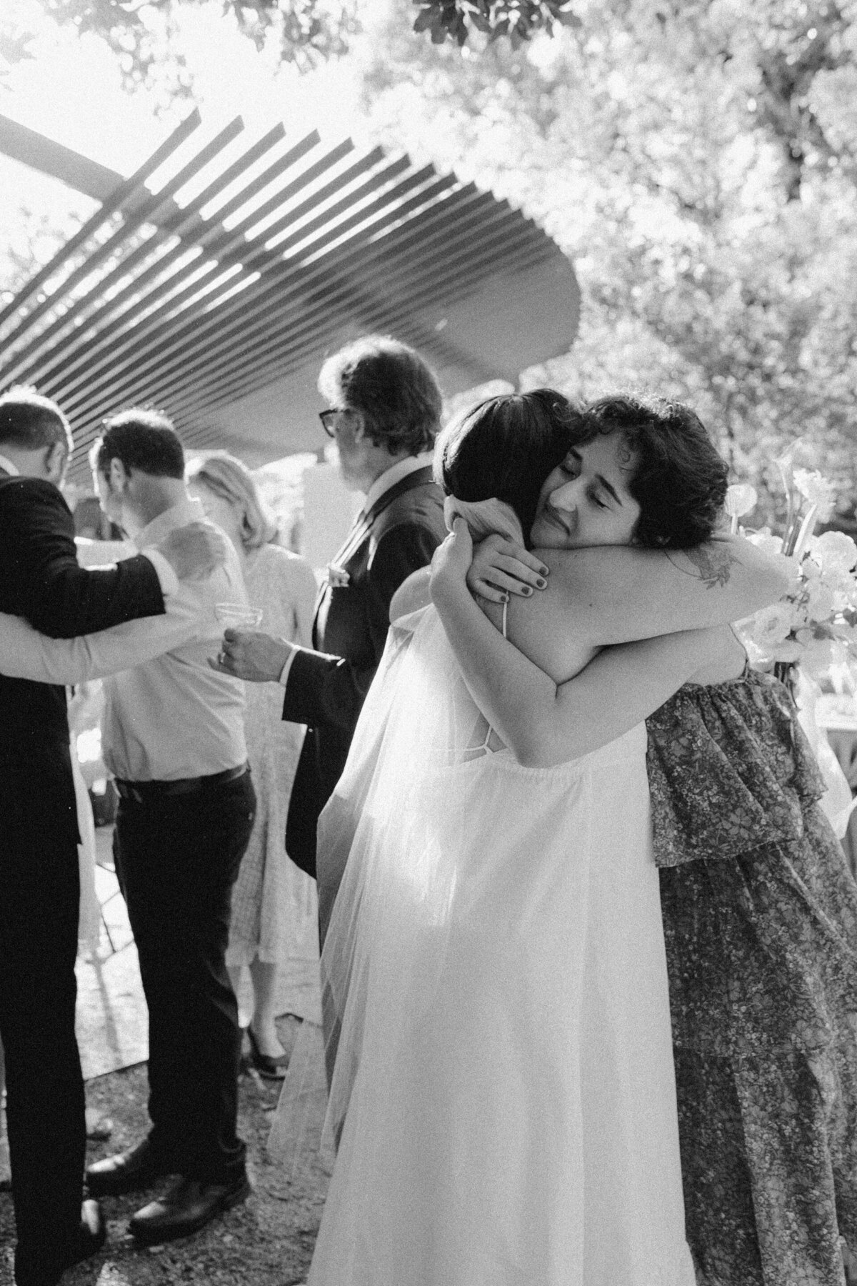 Bride hugging wedding guest at Umlauf Sculpture Garden, Austin
