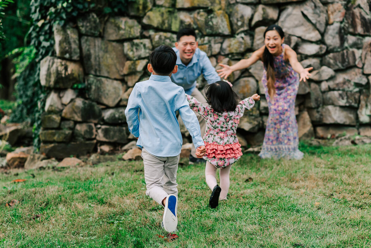 Children running towards their parents' open arms during their family session