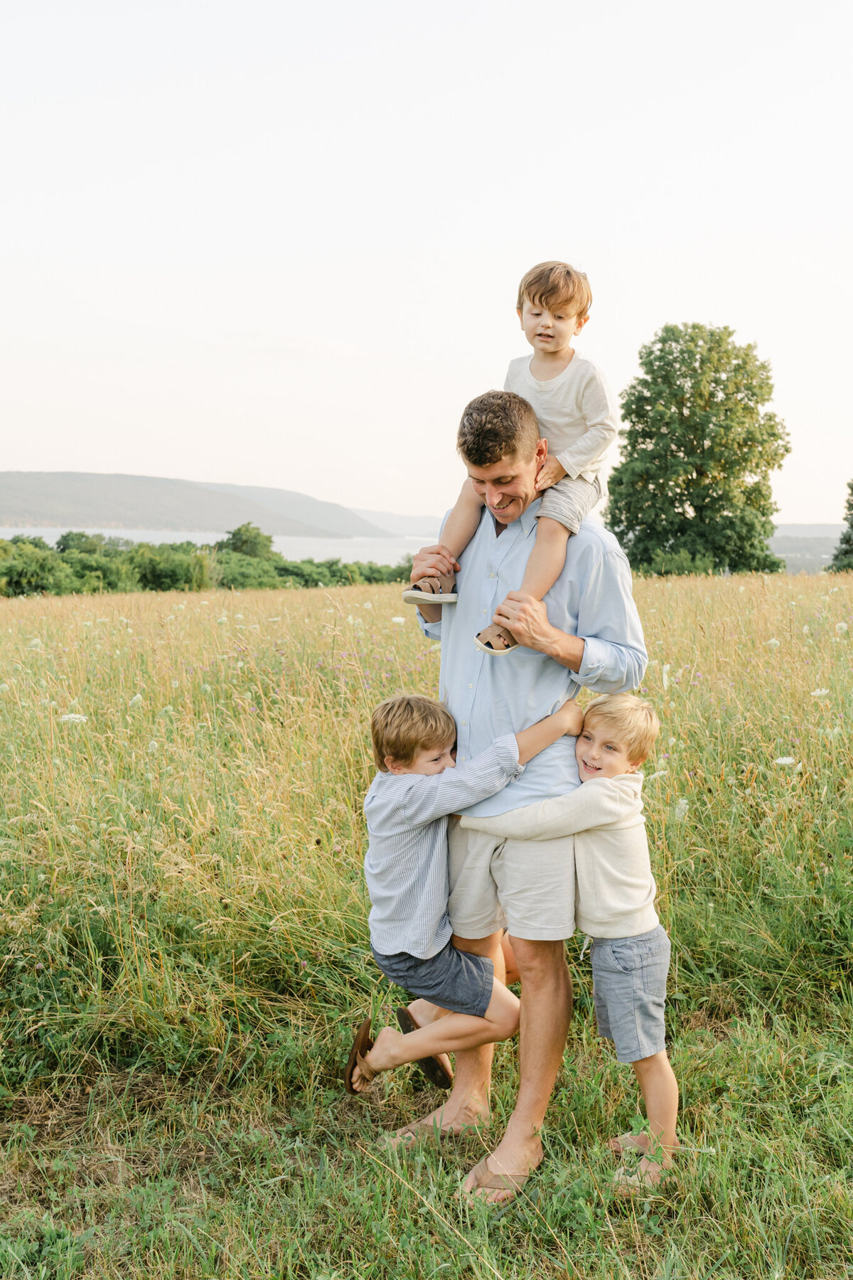 Dad of three boys plays in a field of tall grass outside of Philadelphia