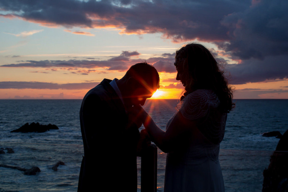 Groom kissing Brides hand at Sunset Devon Beach Weddings