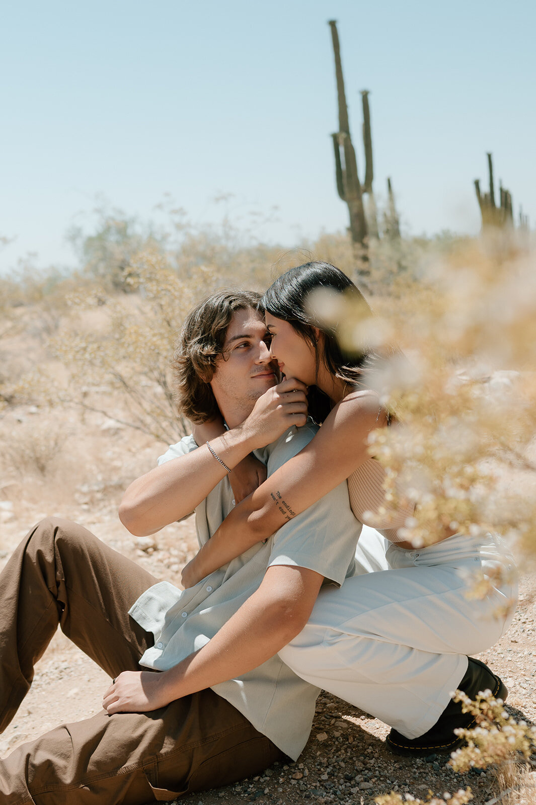 couple sitting in desert during couples photos