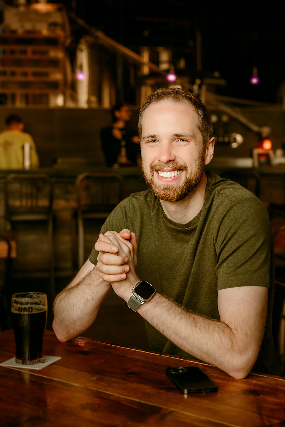 After photo of client smiling confidently at a local brewery, photographed with warm natural light during his online dating portrait session with Shannon Kathleen Photography in St. Paul, Minnesota