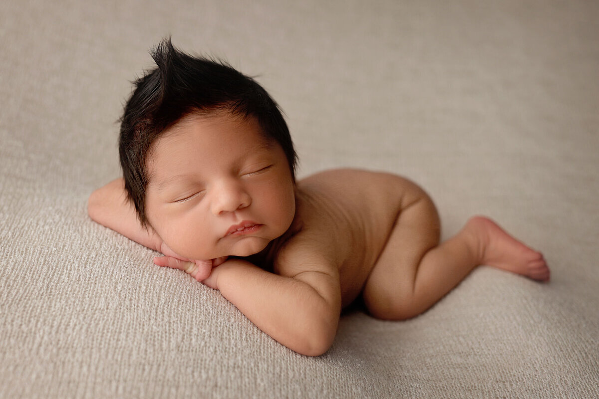 baby boy sleeping on a neutral color blanket posed by the best NJ newborn photographer