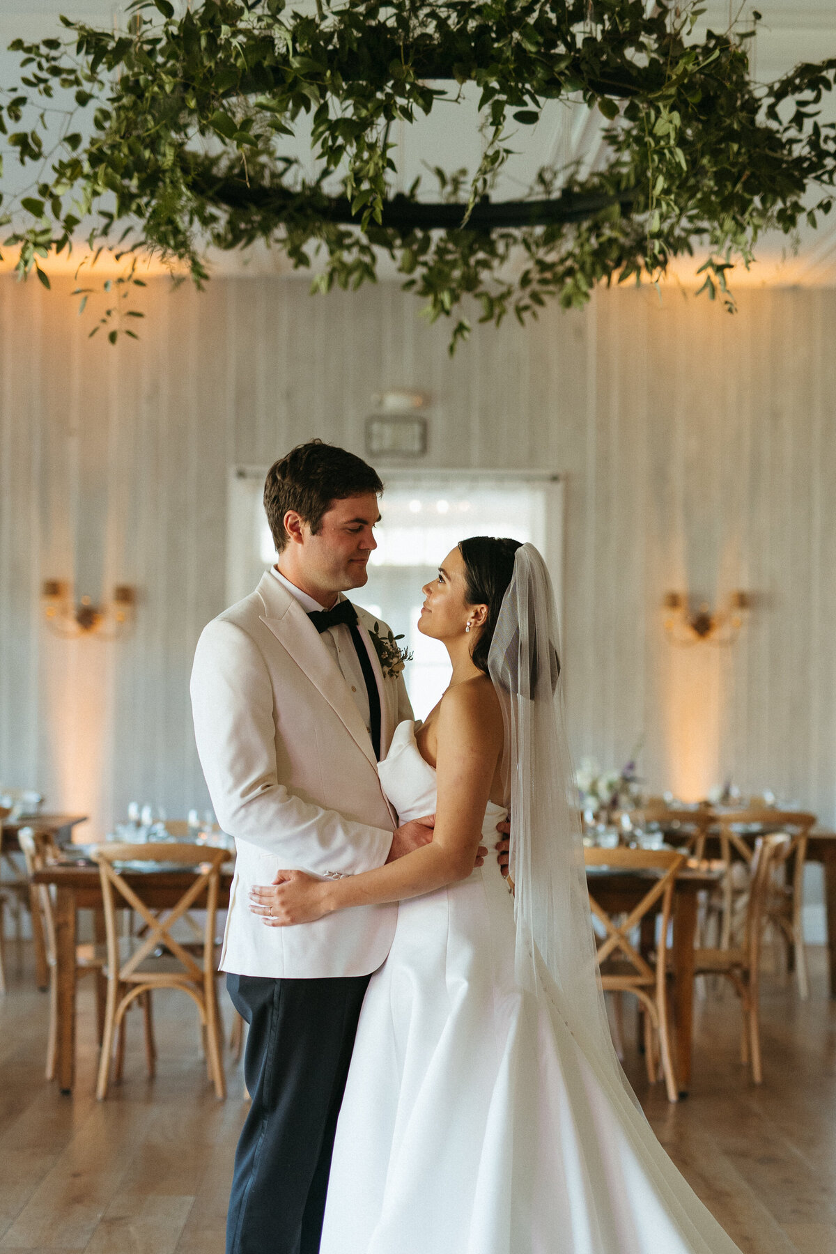 bride and groom under chandelier