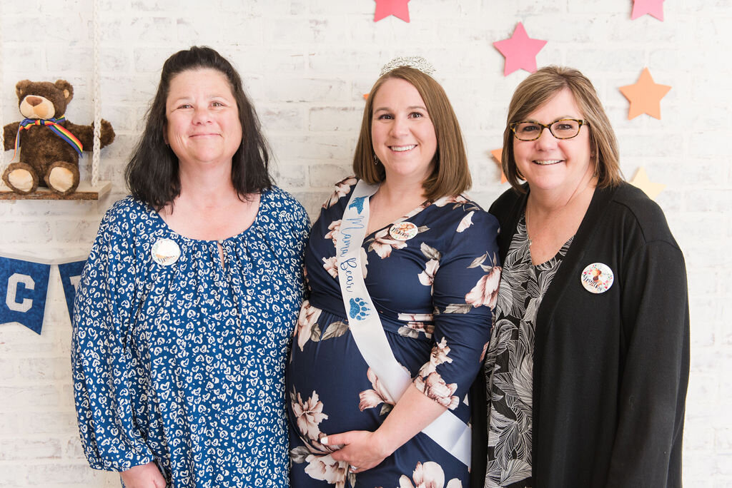 Mom-to-be with grandmothers-to-be at a woodland-themed baby boy shower.