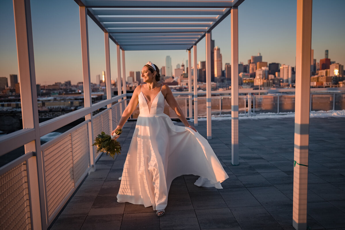 The sunset shines on a bride while she walks on a Chicago rooftop