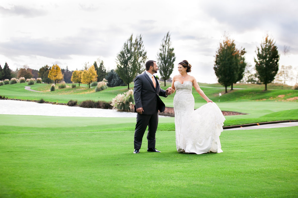 Oregon golf course wedding photo of bride and groom holding hands