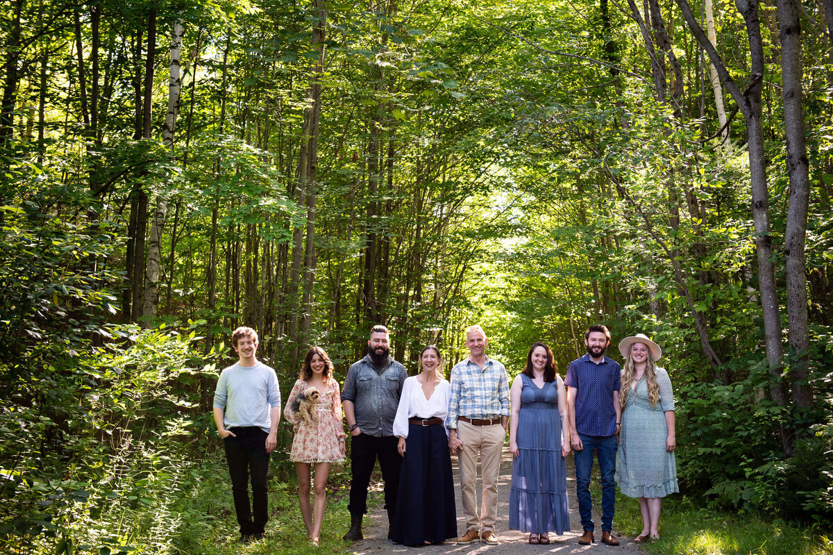 mom and dad with their adult children walking in the woods taken by Ottawa Family Photographer JEMMAN Photography