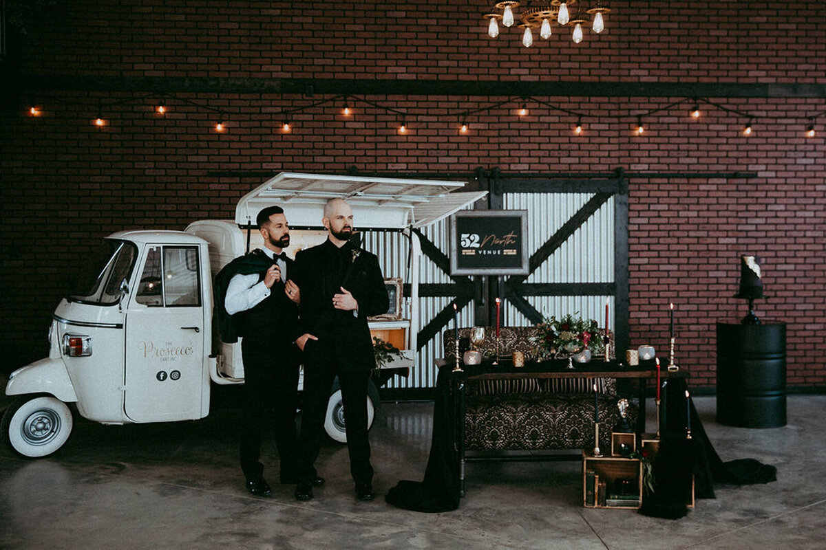 Couple standing at bar cart in 52 North Venue, an industrial and unique wedding venue in Sylvan Lake, AB, featured on the Brontë Bride Vendor Guide.52 North Venue, an industrial and unique wedding venue in Sylvan Lake, AB, featured on the Brontë Bride Vendor Guide.