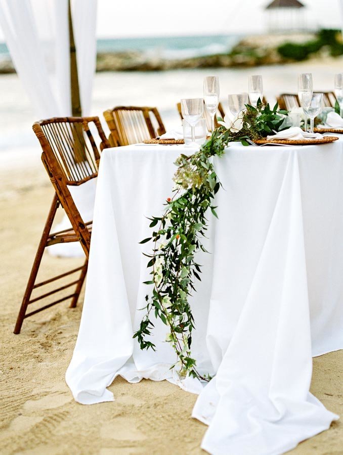 White Tablecloth Bamboo Folding Chairs Green Runner Beach Wedding Dinner © Bonnie Sen Photography