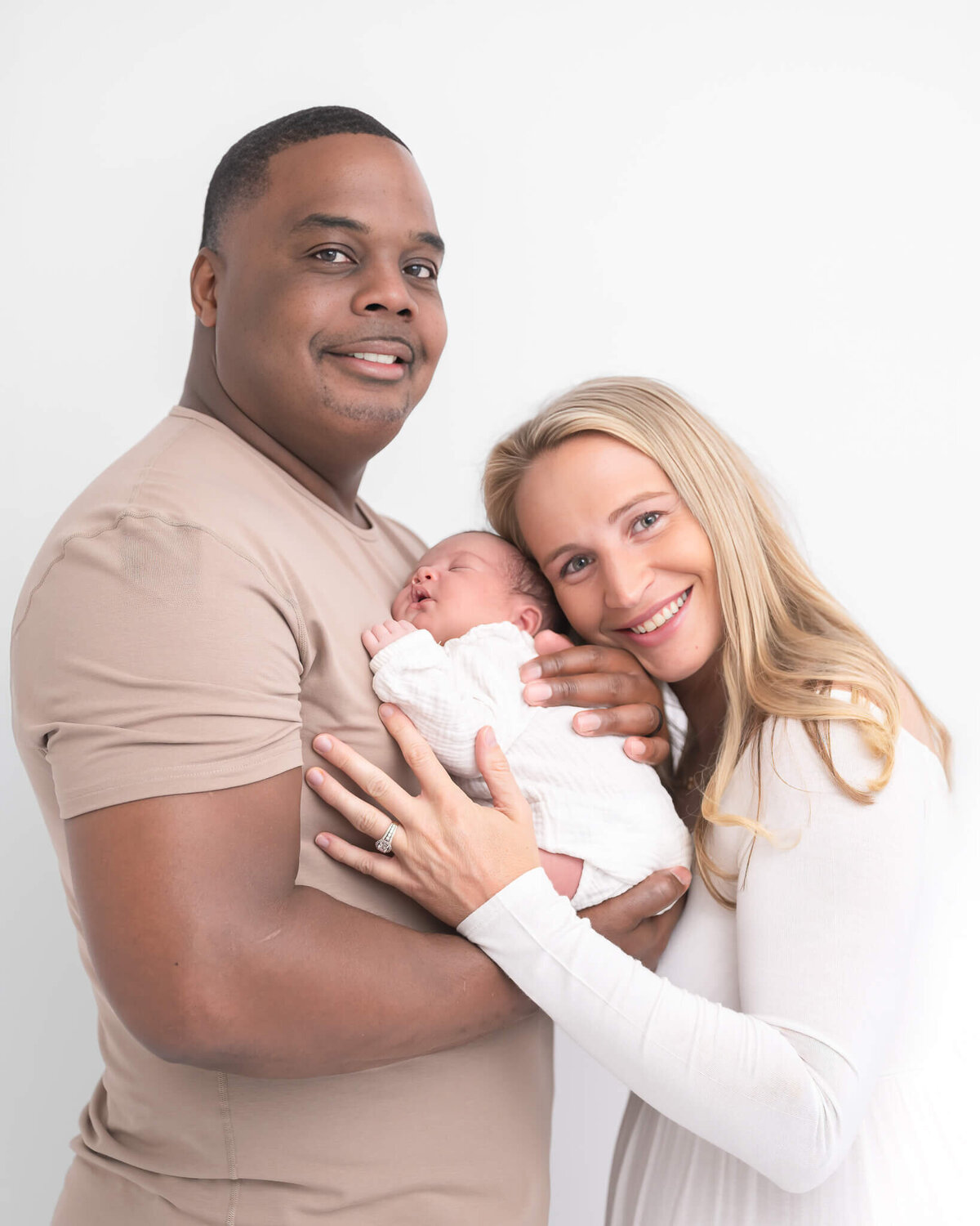 mom dad and new baby in beautiful white, light studio session