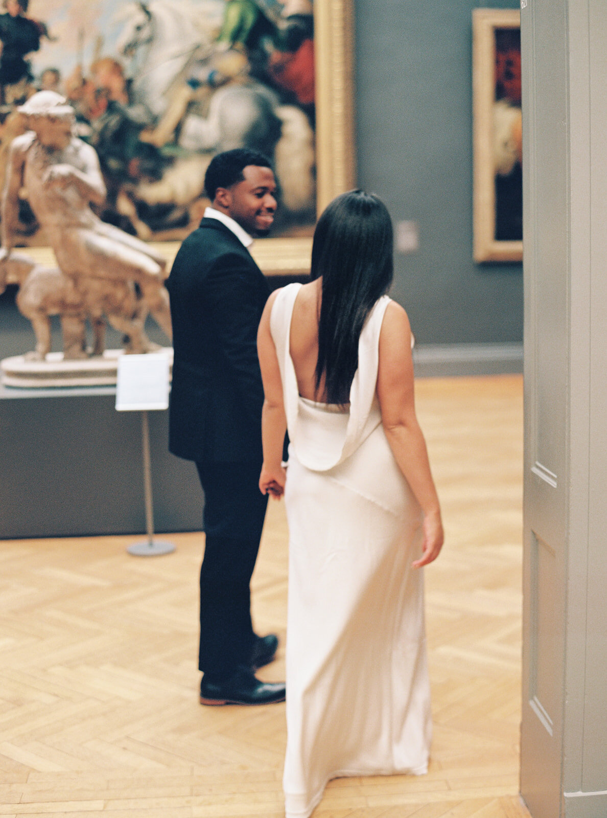 romantic couple casually walking around the MET, looking at paintings