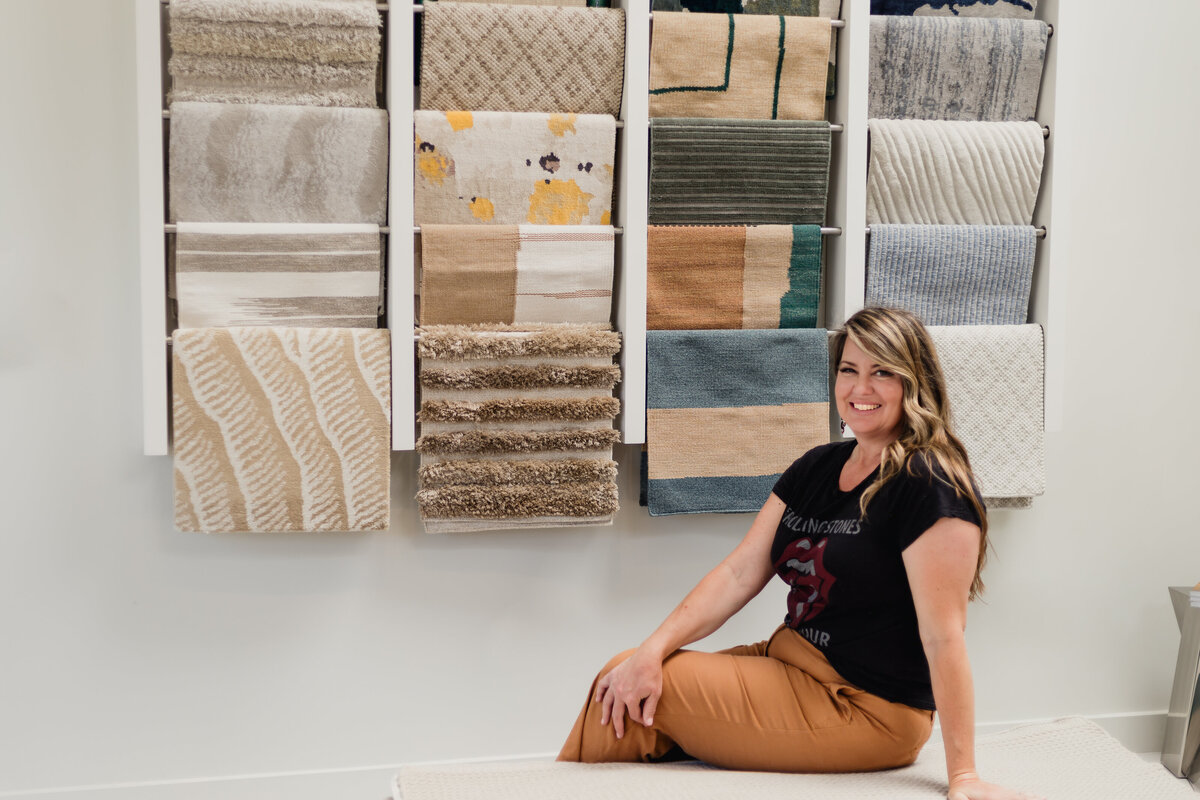 Interior Designer in showroom sitting in front of a wall of textiles