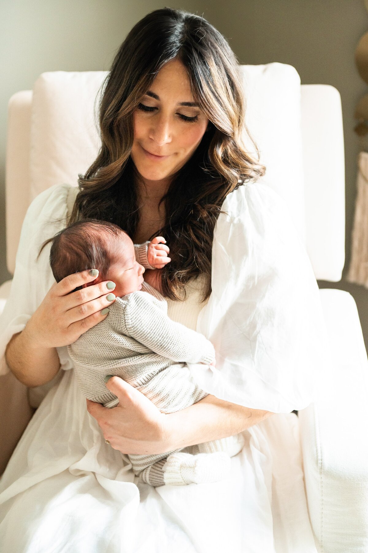 mom looking down at the newborn baby sleeping
