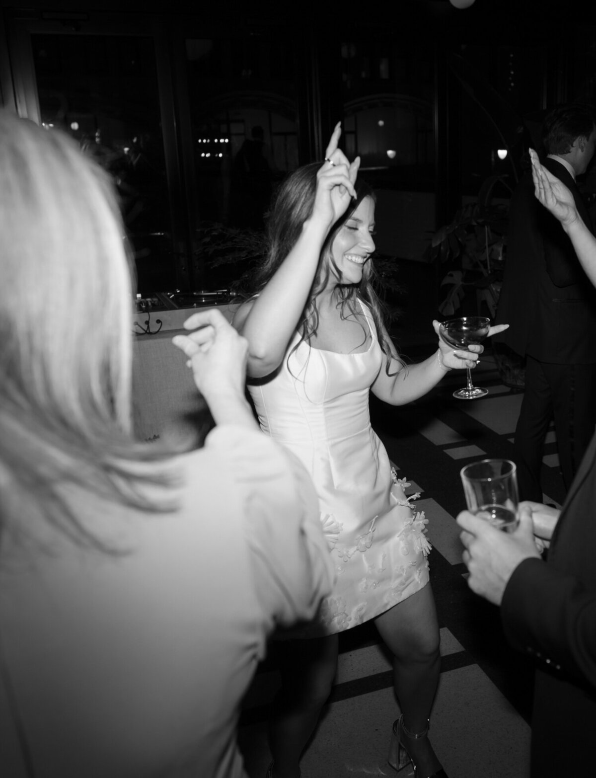 candid wedding photography, bride in short second dress dancing with espresso martini at Shinola Hotel